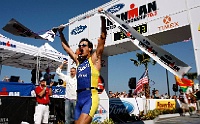 Ironman Finish PIM 027  A runner celebrates while crossing the finish line during the Clearwater IronMan competition. - PhotosinMotion.net. : runner celebrating photograph, pictures of finishlince celebration, Clearwater IronMan finishline, SPORTS, MARATHON, PhotosinMotion.net